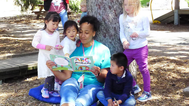 Childcare provider reading to a group of children