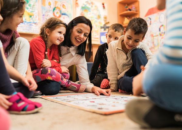Children and caregiver playing at daycare