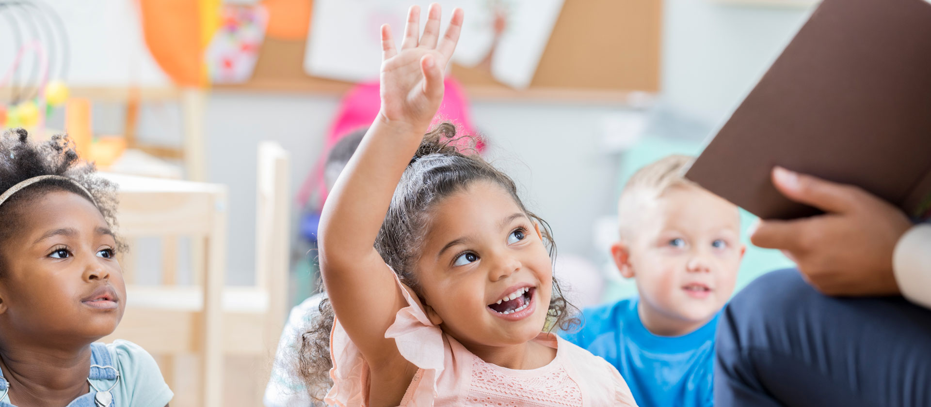 Girl in daycare raising her hand