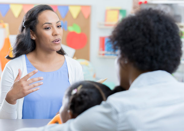 Daycare administrator meeting with a parent and child