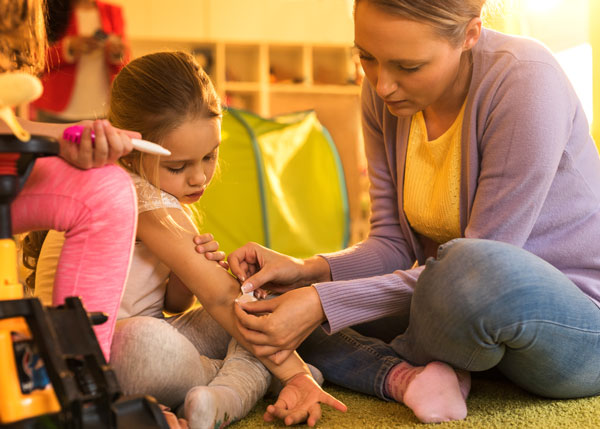 Daycare provider putting a bandaid on a child