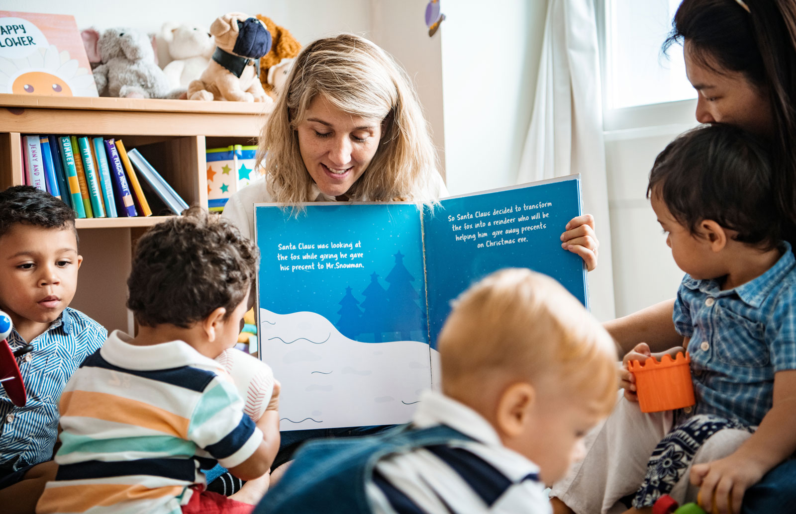 Children reading with a childcare provider.