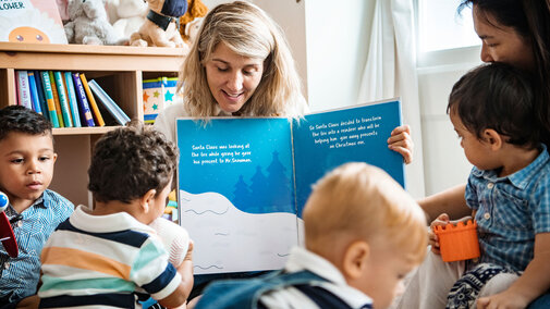 Children reading with a childcare provider.
