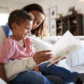 Caregiver and young child reading a book