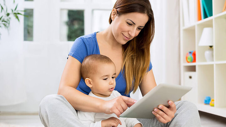 Mom with son on her lap looking at an iPad.