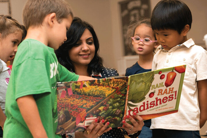 Childcare provider reading to students.