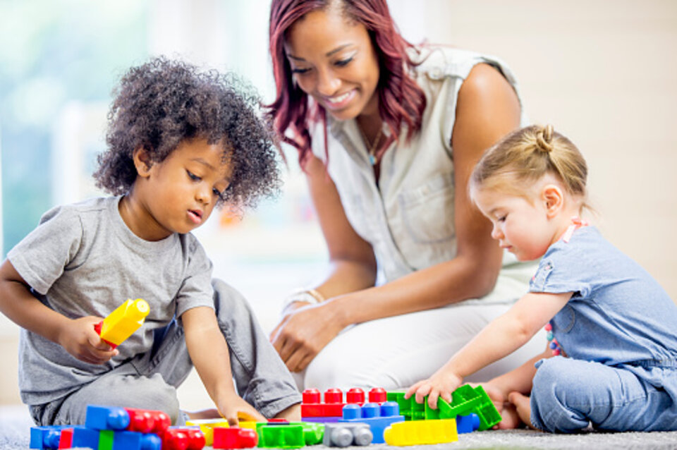 Children and caregiver playing at daycare