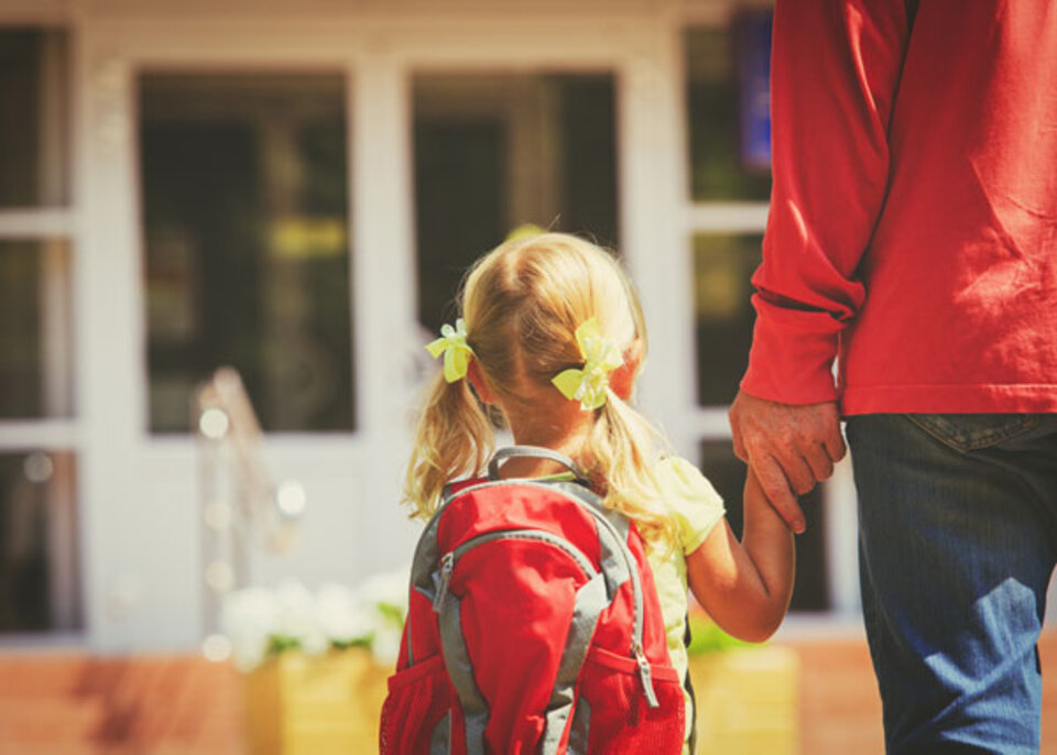 Father walking his daughter into daycare